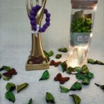 Handmade bracelet of purple wooden beads and white ribbon.                                                                                             سوار لليد مصنوع يدويا من الخرز باللون البنفسجي و مزينة بشريط من اللون الأبيض