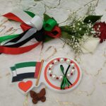 Handmade bracelet of big white pearls and red beads ,designed with green and black ribbon.